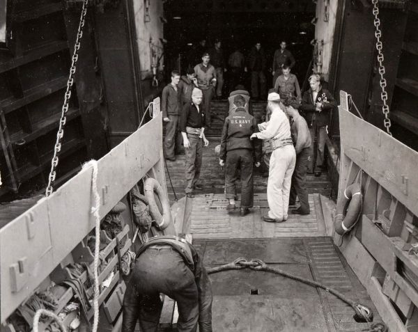 Evacuated from invasion beachhead in France by an LVCP. American casualties are taken aboard an LST offshore. Navy medical corpsmen act as stretcher bearers. NARA REF#: 80-G-252450. Date: 6/8/1944. Taken by: CPU 8 [Motion picture cameraman on the